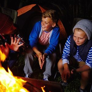 Kids laughing around a campfire