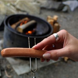 Putting hot dog on two prong roasting stick