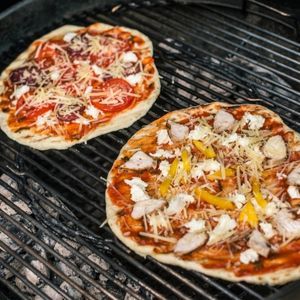 Pizzas cooking on the grill when camping.